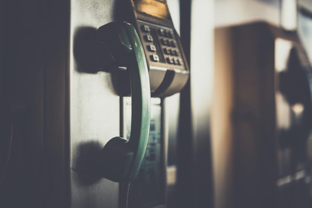 Pay telephone hanging next to payment system with keypad