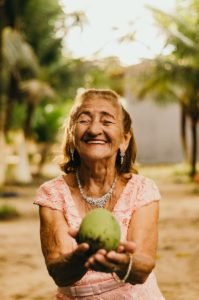 Happy Older Woman Holding Fruit
